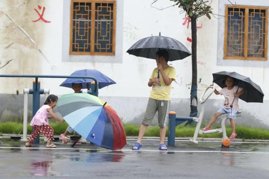 △图为郎楼庄台，孩子在雨中嬉戏。朱立新摄