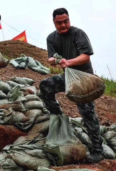 受持续强降雨影响，湖南岳阳县出现险情，退役军人火速抢险，安全护堤。图/文  龙春涛  周金良