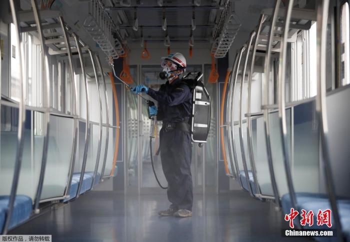  当地时间7月9日，日本东京，一名戴着防护面具和护目镜的东京地铁员工对车厢进行消毒。
