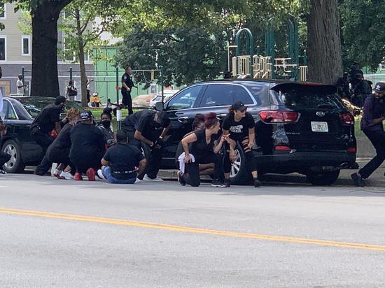 枪响后抗议者躲在汽车后面(图源:推特)
