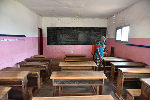 5月29日，一名教职工在喀麦隆首都雅温得即将复课学校内进行消杀作业。新华社发