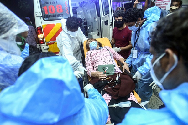 8月7日，在印度喀拉拉邦科泽科德一家医院，医护人员用担架运送伤员。新华社 图