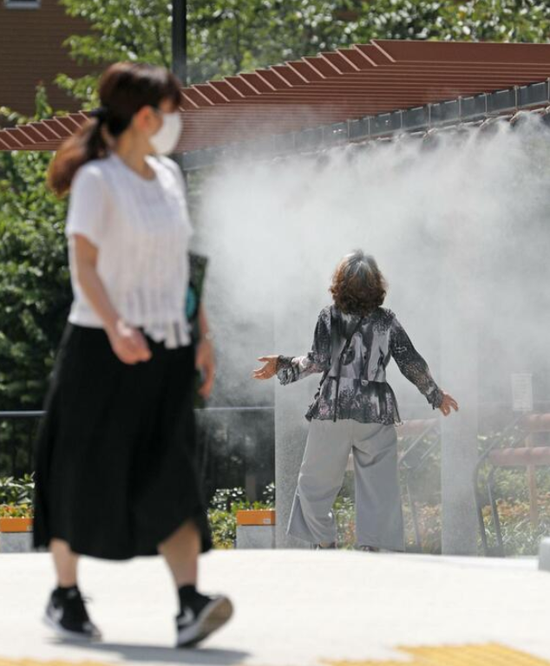  东京银座，人们用喷雾避暑（共同社）