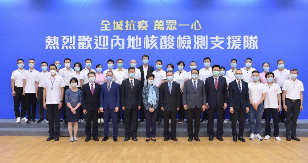 林郑月娥(前排左六)在中西区中山纪念公园体育馆出席欢迎内地核酸检测支援队抵港的仪式