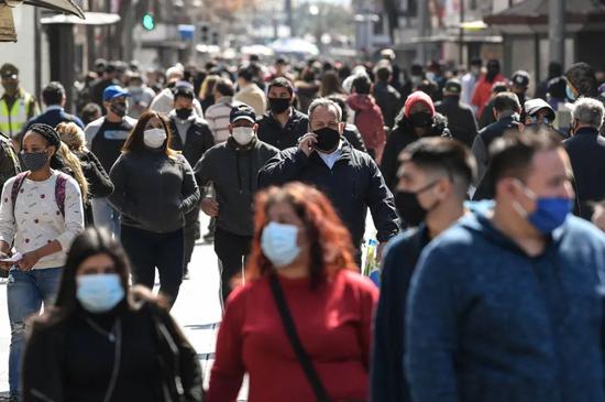 8月25日，戴口罩的行人走在智利首都圣地亚哥街头。新华社发（豪尔赫·比列加斯摄）