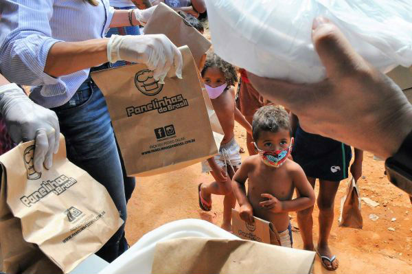疫情期间的巴西圣卢西亚，戴口罩的孩子等待领取食品救济。（美国雅虎新闻网站）