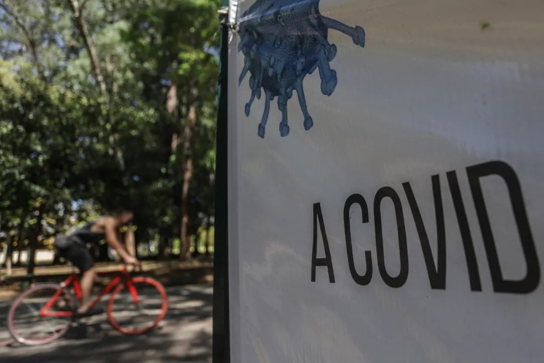 ▲8月26日，在巴西圣保罗市一家公园，一名男子骑车经过写有“冠状病毒”字样的横幅。新华社发（拉赫尔·帕特拉索 摄）