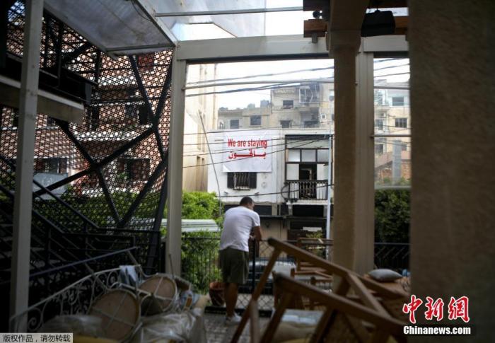 当地时间8月13日，黎巴嫩贝鲁特的一处居民区，一名男子在清理满是瓦砾的公寓。