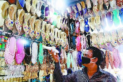 图说：印度商贩销售“印度制造”的女鞋。