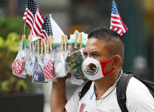  8月19日，一名小贩在美国纽约时报广场售卖口罩。新华社
