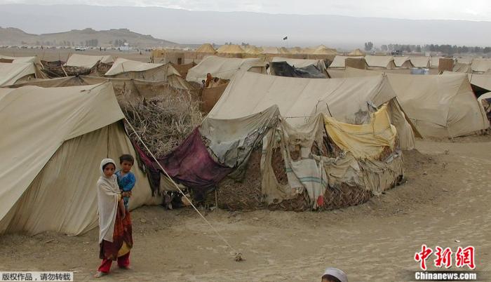 资料图：图为2012年2月15日，两名阿富汗儿童站在难民营前。