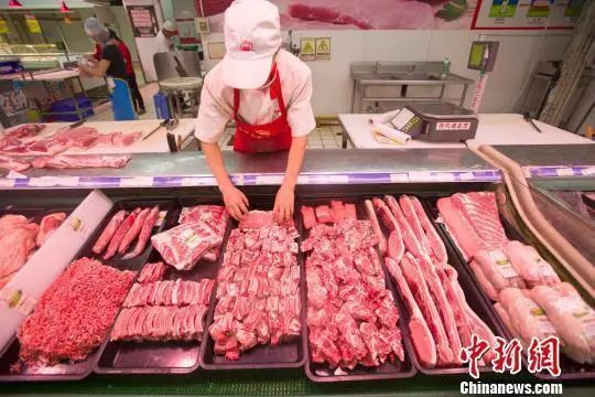 资料图:超市员工在整理猪肉。 张云 摄
