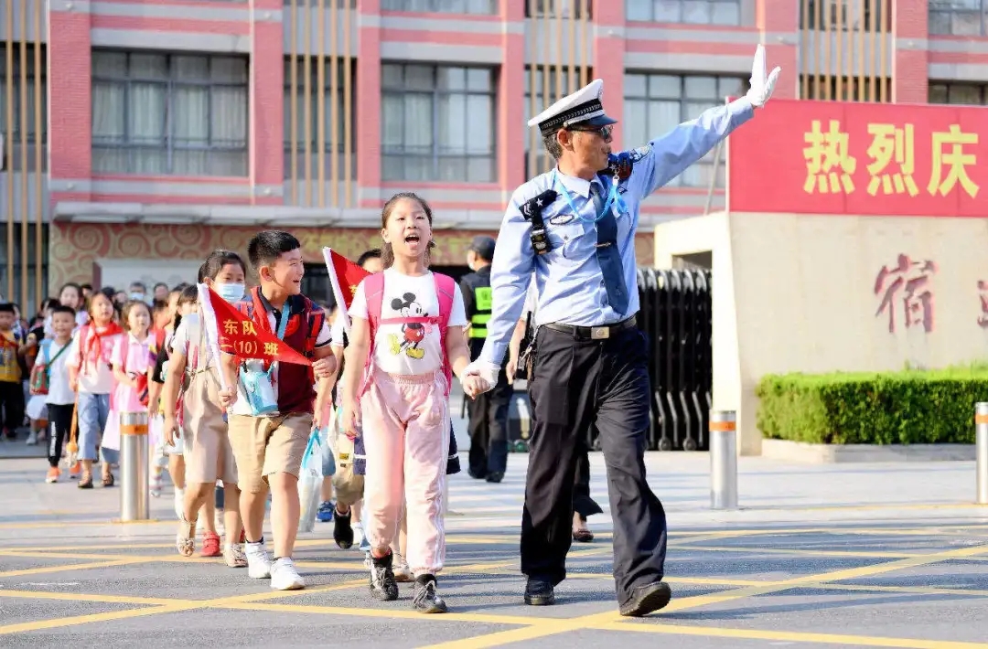 △宿迁辅警护送学生过马路