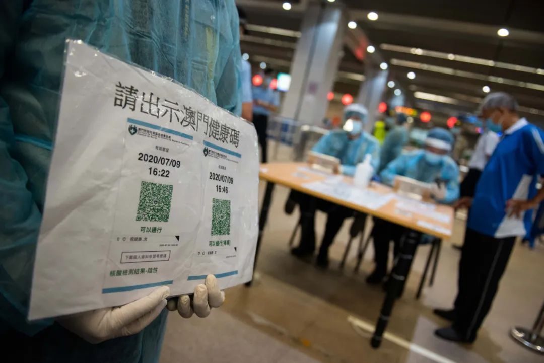 9月29日,工作人员在澳门关闸口岸提示抵澳人士出示澳门健康码。图片来源:新华社 张金加 摄