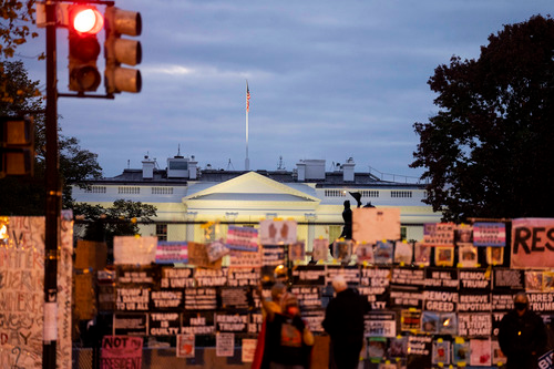 ▲10月31日傍晚在美国华盛顿拍摄的白宫，铁栅栏上挂满抗议标语。（新华社记者 刘杰 摄）