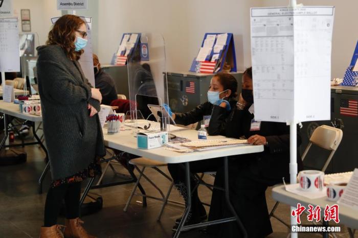 当地时间11月3日，美国纽约布鲁克林博物馆投票站，工作人员为选民办理登记手续。11月3日是2020年美国大选选举日，全美选民前往投票站，为总统大选投票。 中新社记者 廖攀 摄