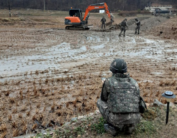 　韩国军人在农田里搜寻导弹残骸