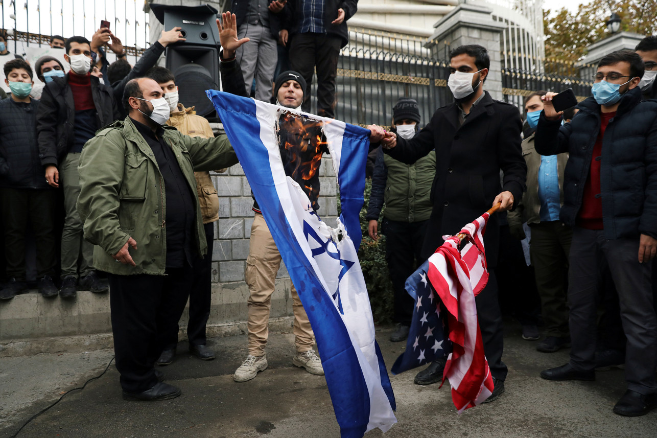 伊朗学生焚烧美国和以色列国旗。（图源 ：法新社）