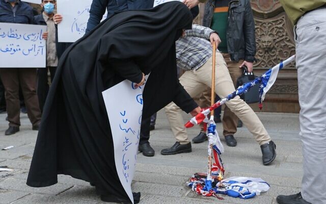 伊朗学生焚烧美国和以色列国旗。（图源 ：路透社）
