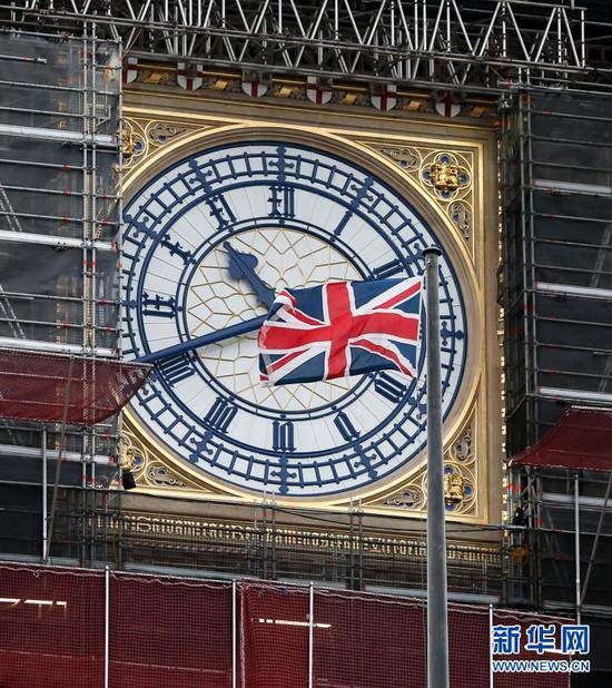 12月21日在英国伦敦拍摄的议会大厦的钟楼“伊丽莎白塔”塔顶的“大本钟”和英国国旗。 新华社记者 韩岩 摄