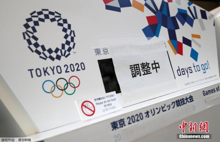 受新冠疫情影响,2020年东京奥运会推迟至2021年夏天举行。图为日本东京中央区,一原本显示东京奥运会倒计时的电子屏被贴上了“正在调整”的字样,下方奥运会的原定举办日期也被遮挡了起来。