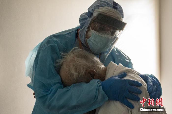 当地时间2020年11月26日，美国休斯敦，联合纪念医疗中心的医生约瑟夫·瓦龙在感恩节期间拥抱并安慰新冠肺炎重症监护室（ICU）的一名患者。图片来源：视觉中国