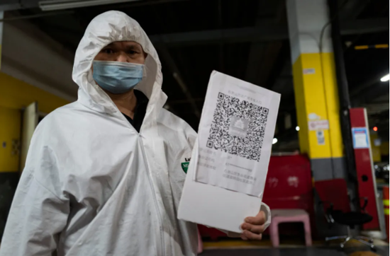 7月9日，北京石景山万达广场地下停车场入口处，工作人员指引市民们通过“北京健康宝”扫码登记。