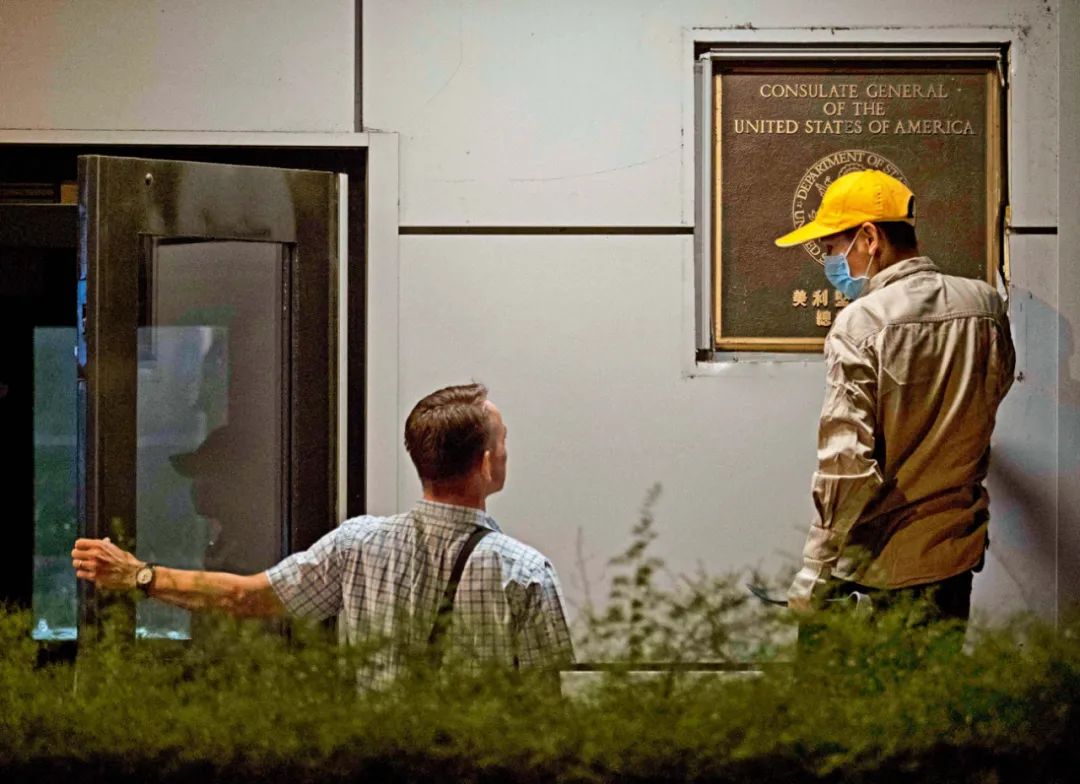  2020年7月26日21点，四川成都，美国驻成都总领事林杰伟（左）在询问工人拆除铭牌相关事宜。图/人民视觉