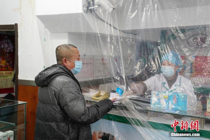 资料图：1月13日，哈尔滨市民在香坊区一家药店里购买口罩。 中新社记者 吕品 摄