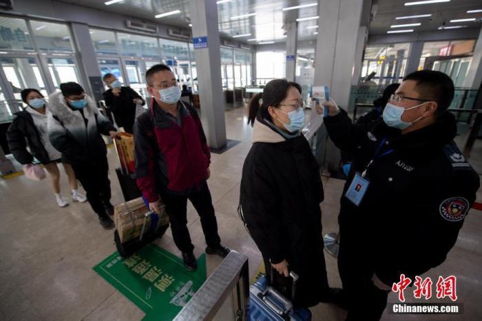1月27日，山西太原站，工作人员为进站旅客测量体温。 中新社记者 韦亮 摄