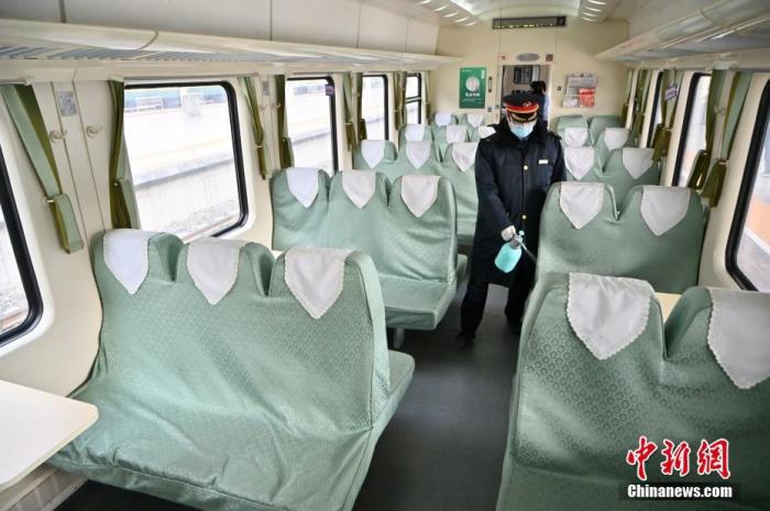 1月25日，内蒙古呼和浩特，列车员在火车车厢内喷洒消毒液。 中新社记者 刘文华 摄