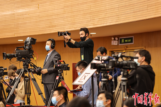 3月4日晚，北京梅地亚中心，十三届全国人大四次会议新闻发布会现场，一位外国记者举起相机拍摄。 中青报·中青网记者 曲俊燕/摄