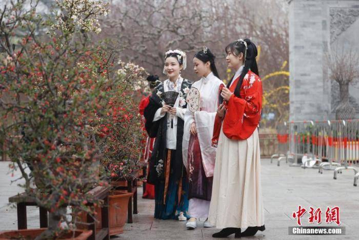 资料图：3月26日，身着汉服的女孩在北京陶然亭公园欣赏海棠花。 中新社记者 杜洋 摄