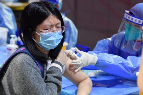 3月27日，北京大学的学生在邱德拔体育馆接种新冠疫苗。