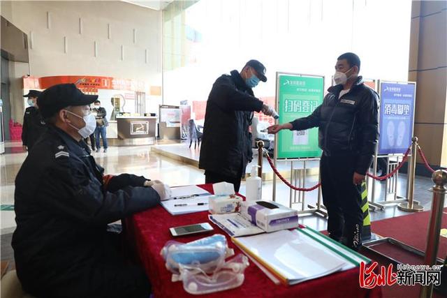3月16日，香河家具城入口处安保人员给进入商场的商户测量体温。
