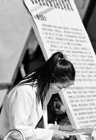 2022年4月24日,在甘肃省高校毕业生专场招聘活动现场,招聘单位工作人员查看大学生简历。王将摄/光明图片